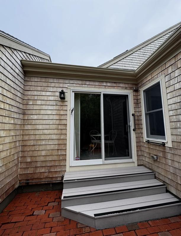 Same entry with bright shingles and clean brick patio after washing