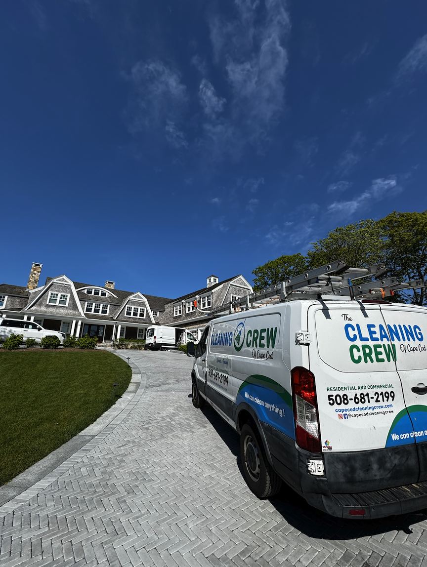 The Cleaning Crew of Cape Cod van parked at a shingle-style home on a sunny day